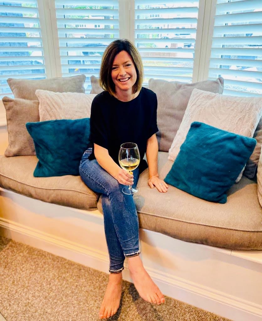 nutritionSian barker relaxing on a sofa with a glass of wine looking happy
