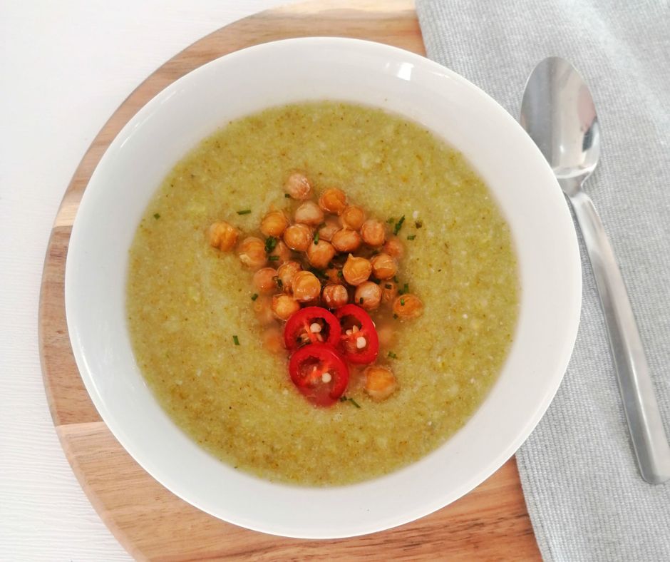 Bowl of broccoli Soup topped with chickpeas and chilli