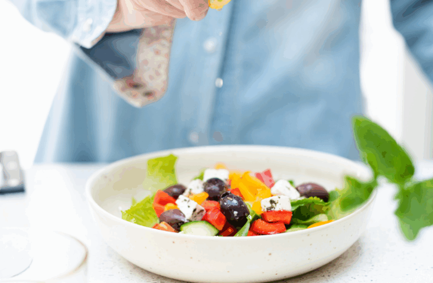 Close-up of a busy professional woman squeezing lemon onto a colourful salad. Soft lighting, calm atmosphere.
